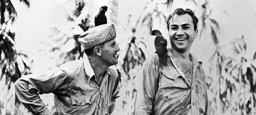 <p>(Original Caption) 3/13/1943-Guadalcanal-Corporal Barney Ross of the United Staes Marine Corps is shown in this photo with Father Frederick Gehring,Catholic Chaplain on Guadalcanal,as they made friends with two "Peace Birds"who alighted on them on Island of "Kill or be Killed." Ross has paid a remarkable tribute to Father Gehring,who is a former teacher at St. John's Prep School in Brooklyn.Over his heart Ross wears a little Catholic medal next to his own Jewish Mezuzeh. The medal was given him by Father Gehring.</p>